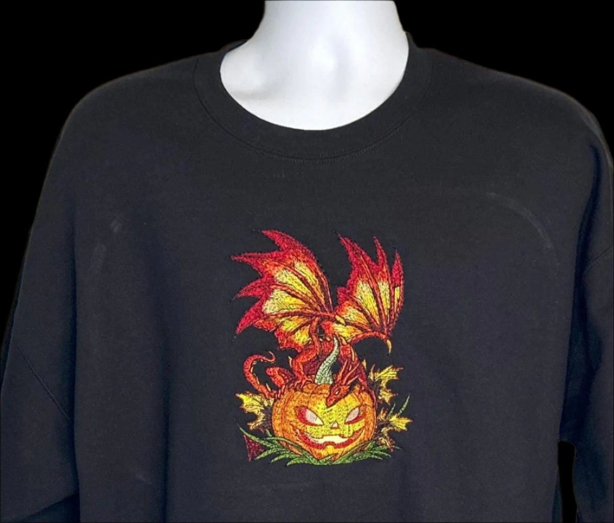 Black sweatshirt with a dragon and pumpkin design on a mannequin against a neutral background