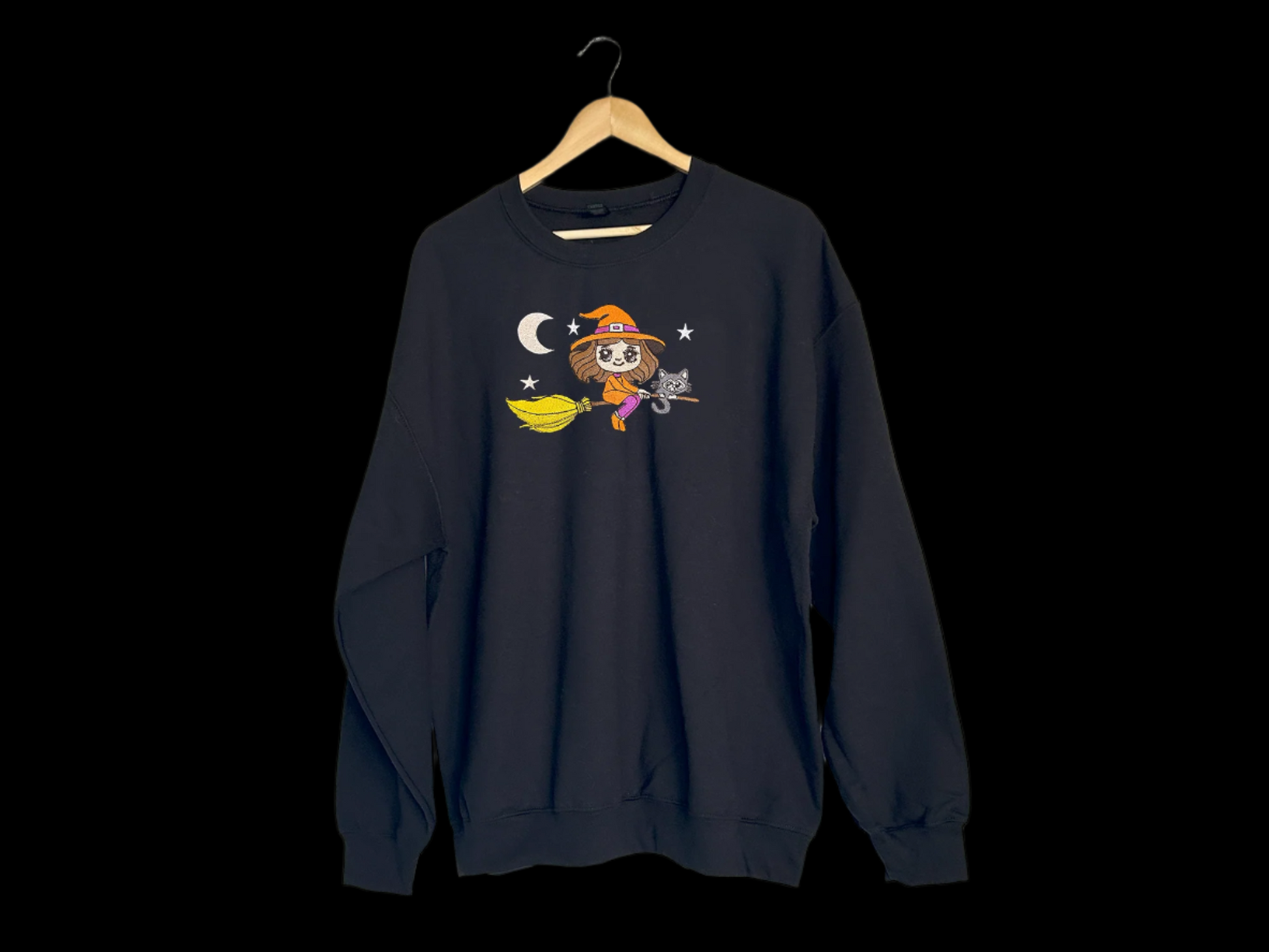 Black sweatshirt with a cartoon character on a hanger against a white background