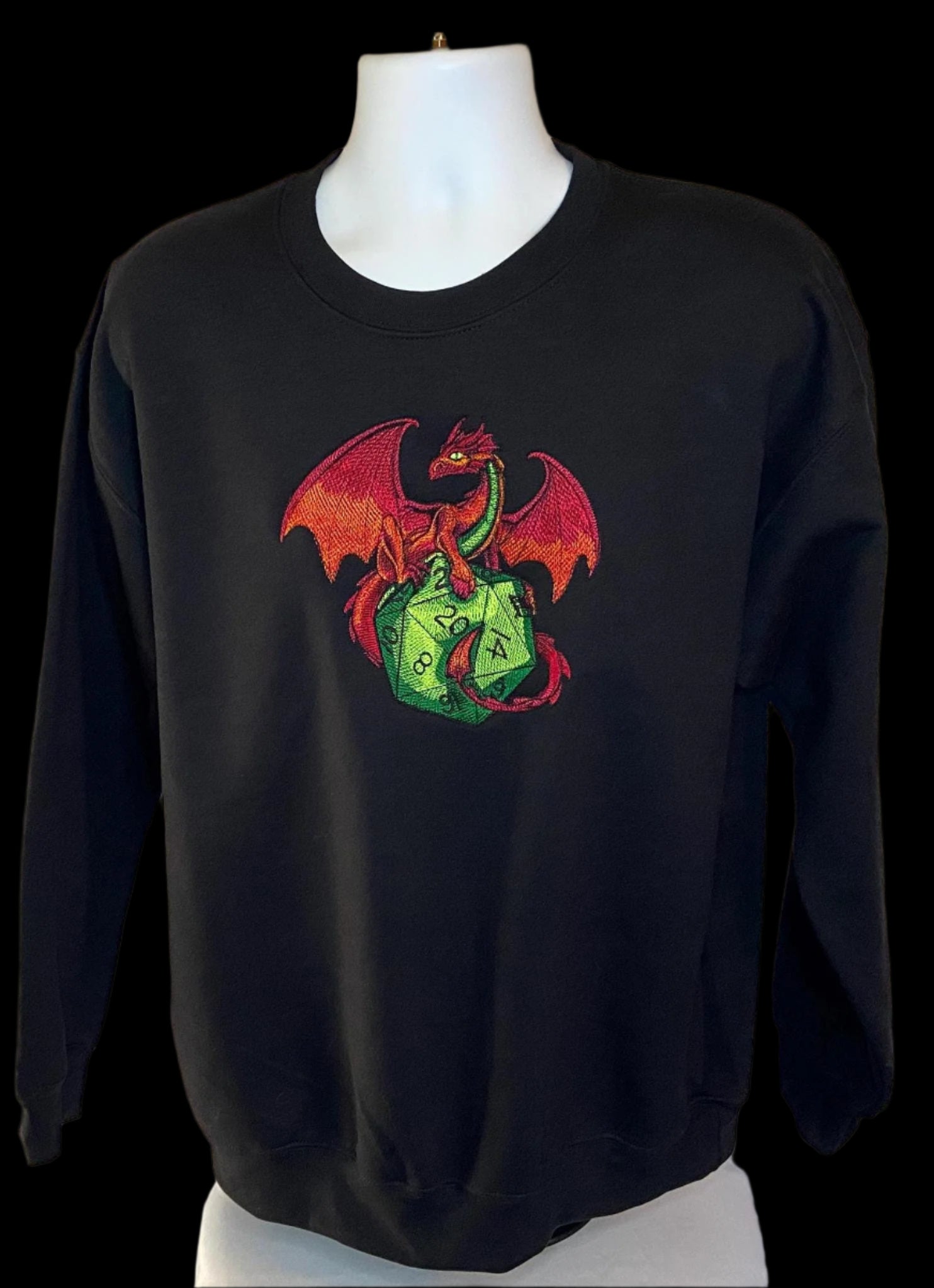 Black sweatshirt with a colorful dragon and dice design on a mannequin against a white background