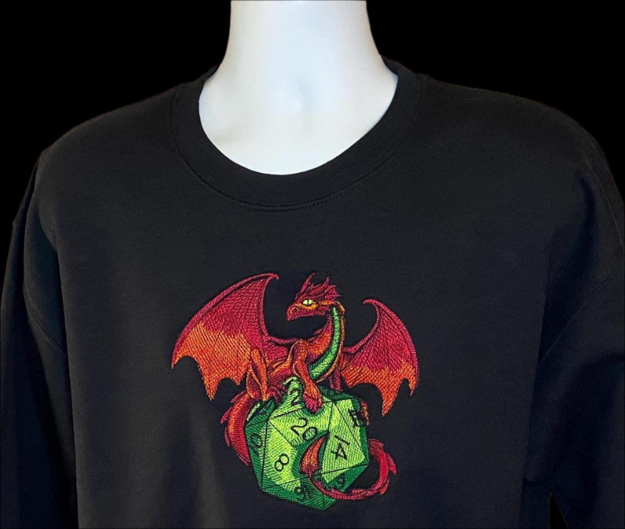 Black sweatshirt with a colorful dragon design on a mannequin against a beige background