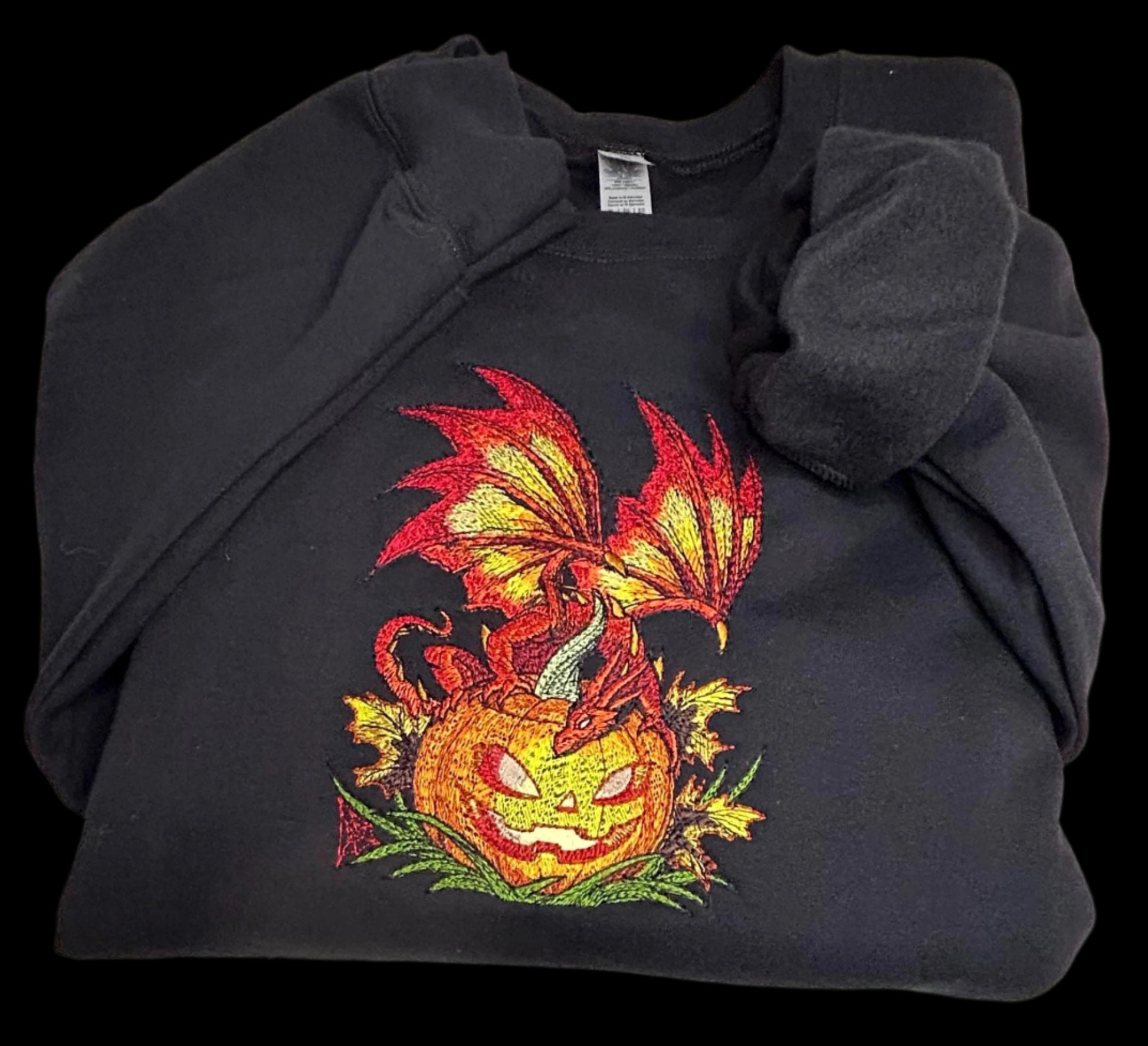 Black sweatshirt with a dragon and pumpkin design on a white background